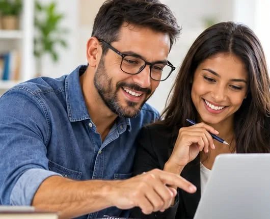 Duas pessoas adultas estudando juntas em frente a um notebook